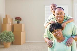 familia afroamericana en la habitación con cajas de mudanza llenas foto