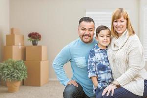 Mixed Race Family with Son in Room with Packed Moving Boxes photo