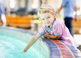 Cute Young Caucasian Boy Enjoying The Fountain At The Park photo