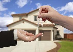 Handing Over the House Keys in Front of New Home photo