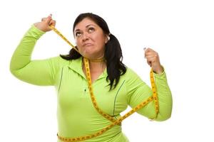 Frustrated Hispanic Woman Tied Up With Tape Measure photo