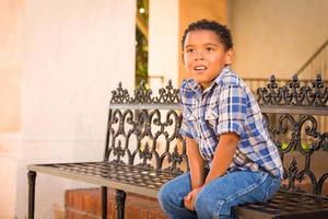 Handsome African American and Mexican Boy Sitting on Park Bench photo