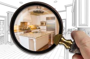 Hand Holding Magnifying Glass Revealing Finished Kitchen Build Over Drawing photo