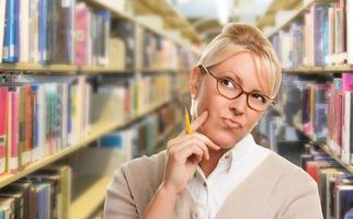 hermoso estudiante expresivo o profesor con lápiz en la biblioteca. foto