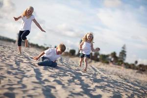 Adorable Brother and Sisters Having Fun at the Beach photo