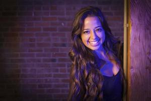 Pretty Mixed Race Young Adult Woman Against a Brick Wall photo