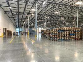 Massive Empty Industrial Warehouse Interior With Stacked Pallets photo