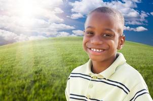 chico afroamericano guapo sobre hierba y cielo foto
