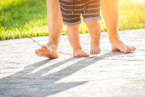 Mother and Baby Feet Taking Steps Outdoors photo