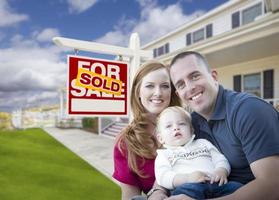 Young Military Family in Front of Sold Sign and House photo