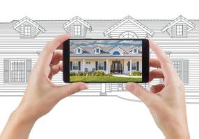 Hands Holding Smart Phone Displaying Home Photo of Drawing Behind