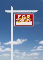 Right Facing Sold For Sale Real Estate Sign on a Blue Sky with Clouds. photo