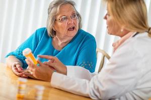 Female Doctor Talking with Senior Adult Woman About Medicine Prescription photo