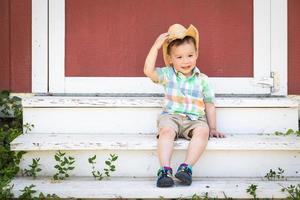 Young Mixed Race Chinese and Caucasian Boy Wearing Cowboy Hat Relaxing On The Steps photo