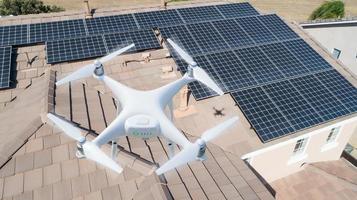UAV Drone Inspecting Solar Panels On Large House photo
