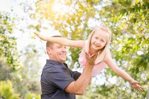 Young Caucasian Father and Daughter Having Fun At The Park photo