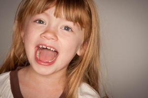 Fun Portrait of an Adorable Red Haired Girl on Grey photo