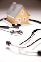 Stethoscope and Model House on Gradated Background photo