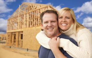 Couple in Front of New Home Construction Framing Site photo