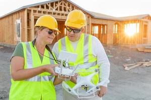 trabajadores con drone quadcopter inspeccionando fotografías en el controlador en el sitio de construcción foto