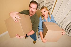 Exhausted Couple Holding Moving Boxes photo