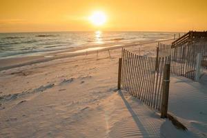 Beautiful Sunset Over the Ocean with Sand Fencing photo