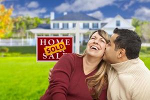 Mixed Race Couple in Front of Sold Real Estate Sign photo