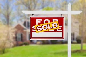 Left Facing Sold For Sale Real Estate Sign In Front of House. photo