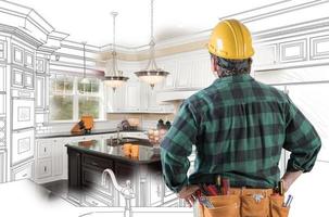 Male Contractor with Hard Hat and Tool Belt Looking At Custom Kitchen Drawing Photo Combination On White.