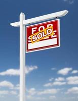 Right Facing Sold For Sale Real Estate Sign on a Blue Sky with Clouds. photo