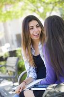 Expressive Young Mixed Race Female Sitting and Talking with Girlfriend photo