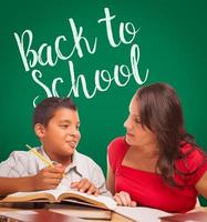 Back To School Written On Chalk Board Behind Hispanic Young Boy and Famale Adult Studying photo