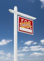 Right Facing Sold For Sale Real Estate Sign on a Blue Sky with Clouds. photo