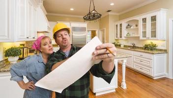 Contractor Discussing Plans with Woman Inside Custom Kitchen Interior photo