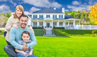 Mixed Race Family In Front Yard of Beautiful House and Property. photo