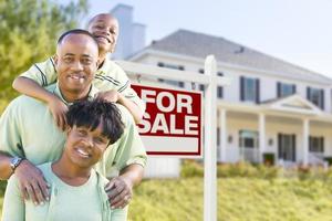 African American Family In Front of Sale Sign and House photo