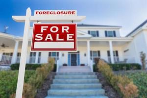 Right Facing Foreclosure For Sale Real Estate Sign in Front of House. photo