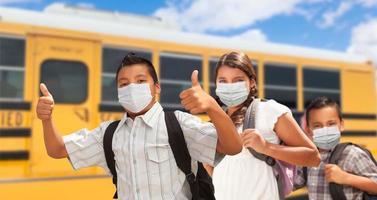 Hispanic Students Near School Bus Wearing Face Masks photo