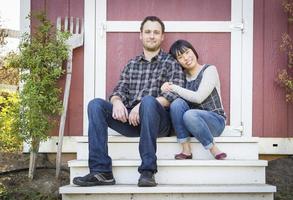 pareja de raza mixta relajándose en los escalones foto