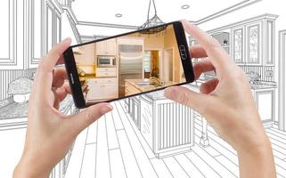 Hands Holding Smart Phone Displaying Photo of Kitchen Drawing Behind