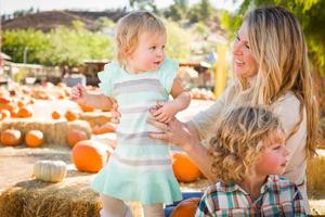 Adorable Young Family Enjoys a Day at the Pumpkin Patch. photo