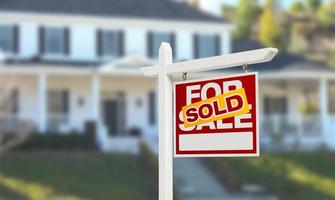 Sold Home For Sale Real Estate Sign in Front of Beautiful New House. photo