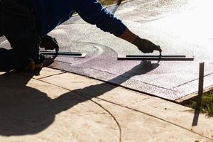 Construction Worker Smoothing Wet Cement With Trowel Tools photo