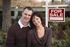 Happy Couple in Front of Real Estate Sign photo