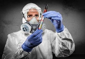 doctora o enfermera en equipo de materiales peligrosos con tubo de ensayo de coronavirus positivo foto