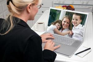 mujer en la cocina usando una laptop - familia y amigos foto