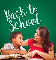 Back To School Written On Chalk Board Behind Hispanic Young Boy and Famale Adult Studying photo