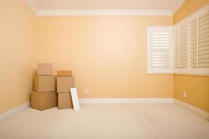 cajas de mudanza y letrero en blanco en una habitación vacía foto