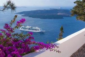 Bougainvillea adorn walkway as passenger cruise ship anchors off the coast of Greece. photo