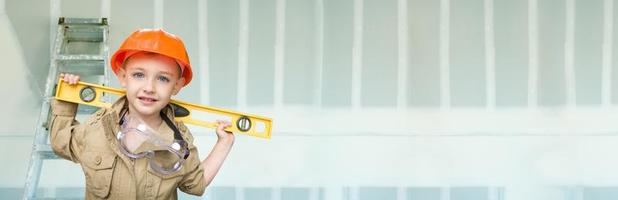 Cute Young Boy Dressed As Contractor Holding Level Against Dywall Banner Background with Ladder photo